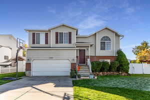 View of front of property featuring brick siding, driveway, and a garage