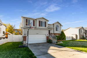View of front of house featuring brick siding, a gate, concrete driveway, and a garage