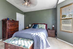 Bedroom with a closet, lofted ceiling, light colored carpet, and ceiling fan