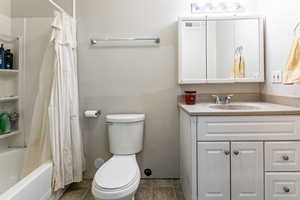 Bathroom featuring light tile patterned floors, shower / tub combo with curtain, and vanity