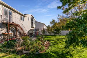 Rear view of house featuring a fenced backyard, stairway, and a patio area