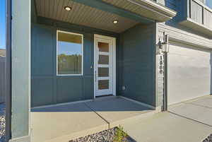 Property entrance with a garage and a porch