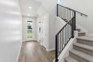 Foyer featuring light wood-type flooring, stairs, and recessed lighting