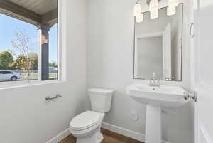 Half bath featuring baseboards and dark wood-style floors