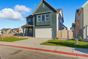 Contemporary home featuring an attached garage, concrete driveway, a gate, and a residential view