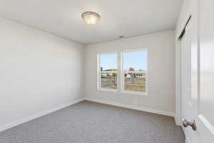 Carpeted empty room with baseboards and a textured ceiling