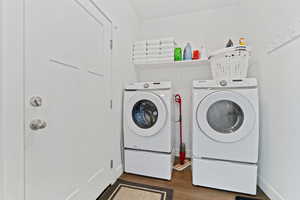 Laundry area featuring dark wood finished floors and washer and dryer