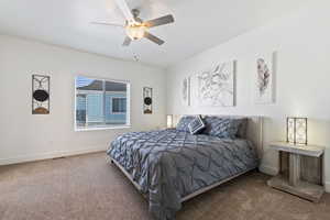 Carpeted bedroom featuring baseboards and a ceiling fan