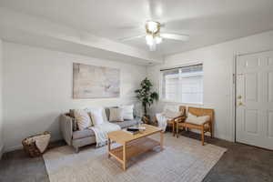 Living area with carpet and a ceiling fan