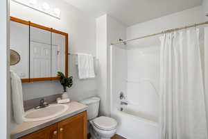 Bathroom featuring shower / tub combo with curtain and vanity