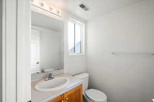 Half bathroom featuring vanity and toilet