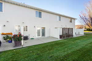 Rear view of house featuring a lawn & private patio