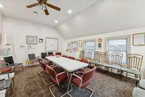 Dining room featuring dark carpet, recessed lighting, ceiling fan, and high vaulted ceiling