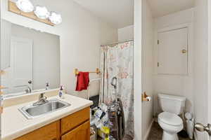 Full bath with a shower with curtain and vanity