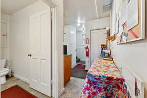 Hallway featuring baseboards and stone finish floors