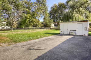 Fenced backyard featuring a shed