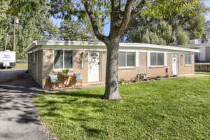 View of front of property featuring a front yard and brick siding