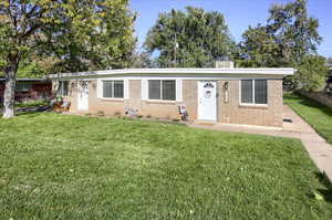 Ranch-style house with a front yard and brick siding