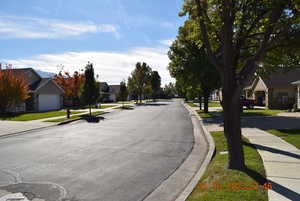 View of asphalt road featuring sidewalks, a residential view, and curbs