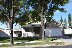 View of front facade featuring a porch, driveway, an attached garage, and brick siding