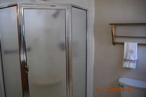Bathroom with a shower stall and toilet