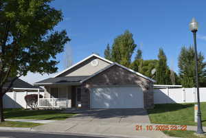Ranch-style house featuring brick siding, covered porch, a gate, concrete driveway, and a garage