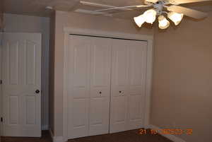 Unfurnished bedroom featuring carpet, a closet, and a ceiling fan