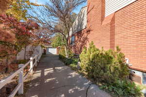 View of side of property featuring brick siding, driveway, and  garage