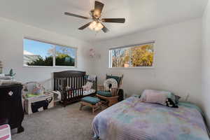 Upstairs Bedroom #2 featuring a nursery area, multiple windows, carpet flooring, and ceiling fan