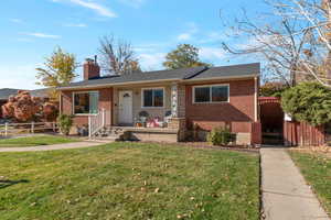 View of front of house with a chimney and brick siding