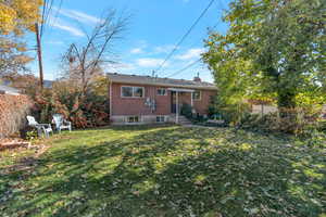 Back of house featuring brick siding and a chimney