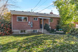 Rear view of property featuring brick siding and a chimney