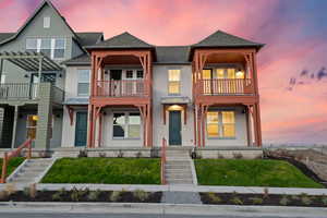 View of front of property featuring stucco siding, a shingled roof, covered porch, and a front yard