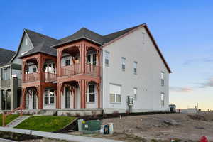 View of front of home with covered porch, a shingled roof, and stucco siding