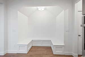 Mudroom featuring dark wood-style flooring and baseboards