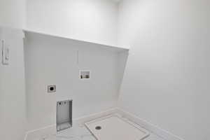 Washroom featuring washer hookup, marble look tile flooring, and hookup for an electric dryer