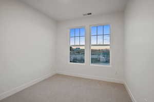 Spare room featuring light carpet and baseboards