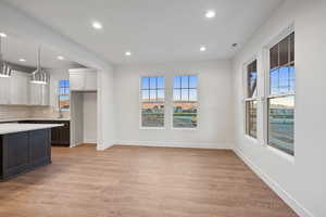 Unfurnished dining area with light wood-style floors and recessed lighting
