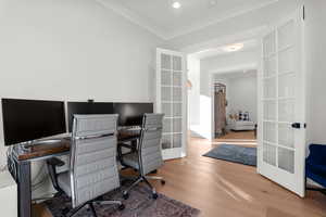 Office space with french doors, light wood-type flooring, and ornamental molding