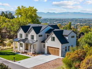 Modern farmhouse style home featuring a porch, board and batten siding, a mountain view, and a standing seam roof