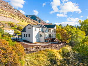 Back of property featuring a fenced backyard, stucco siding, a balcony, a patio area, and stairway