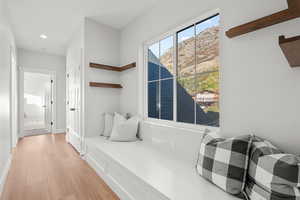 Living area with light wood finished floors, a mountain view, and recessed lighting