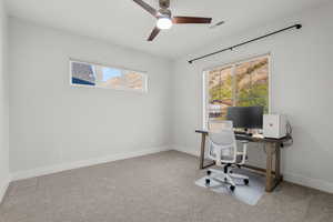 Office area with light colored carpet and ceiling fan
