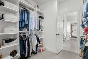 Walk in closet featuring light colored carpet and light tile patterned floors