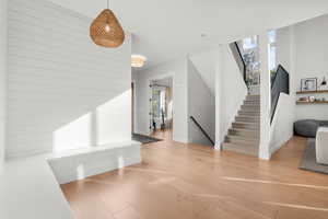 Entryway featuring stairway, healthy amount of natural light, and wood finished floors
