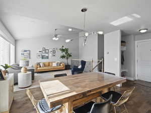 Dining area with vaulted ceiling, dark wood finished floors, and ceiling fan