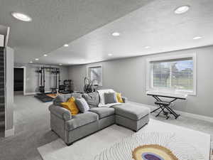 Living area featuring carpet flooring, stairway, a textured ceiling, and recessed lighting