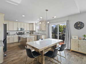 Dining room with dark wood-type flooring, a chandelier, and recessed lighting