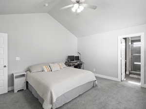 Bedroom with light colored carpet, lofted ceiling, a ceiling fan, and ensuite bathroom