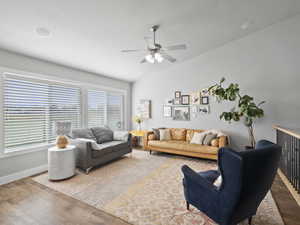 Living room with lofted ceiling, wood finished floors, and ceiling fan